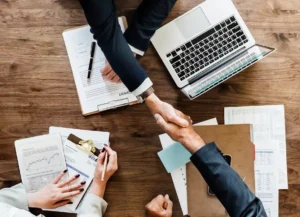 Gente estrechando la mano después de reducir riesgos fiscales